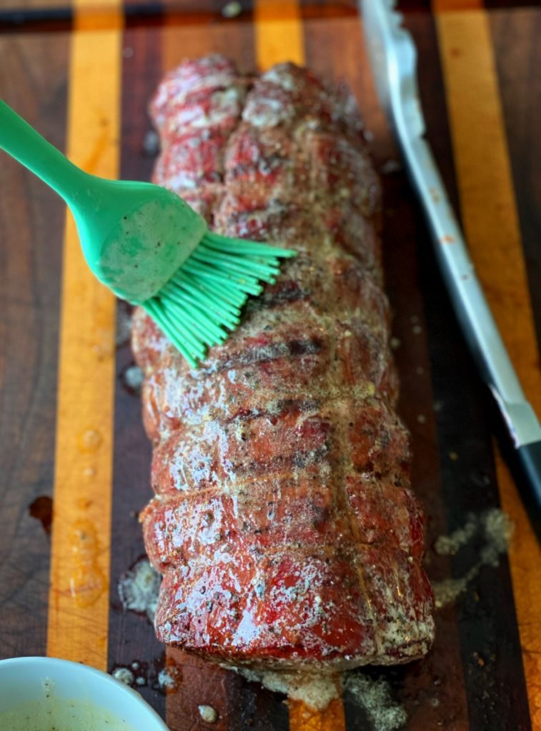 Brushing melted garlic herb butter on top of the smoked beef tenderloin adds extra flavor to the crust.