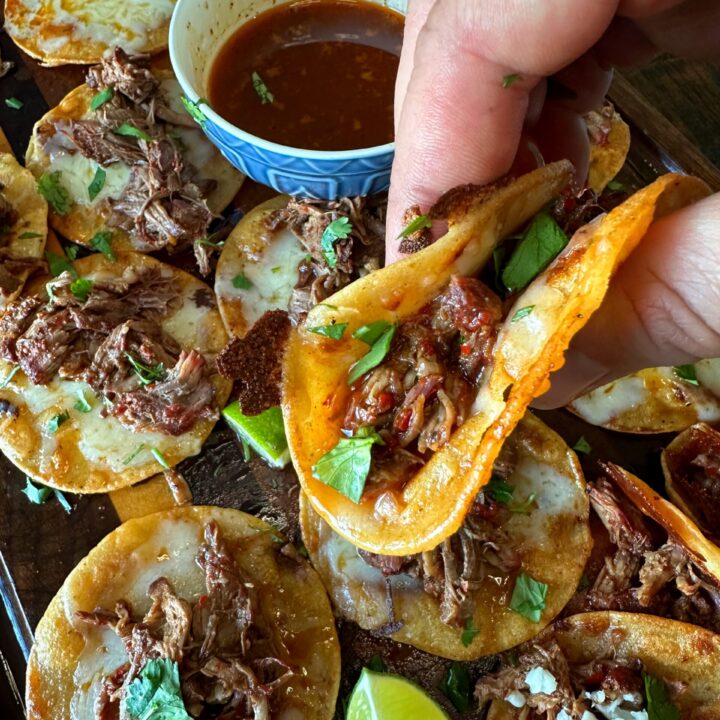 Platter full of Smoked Beef Birria Tacos ready for dipping.
