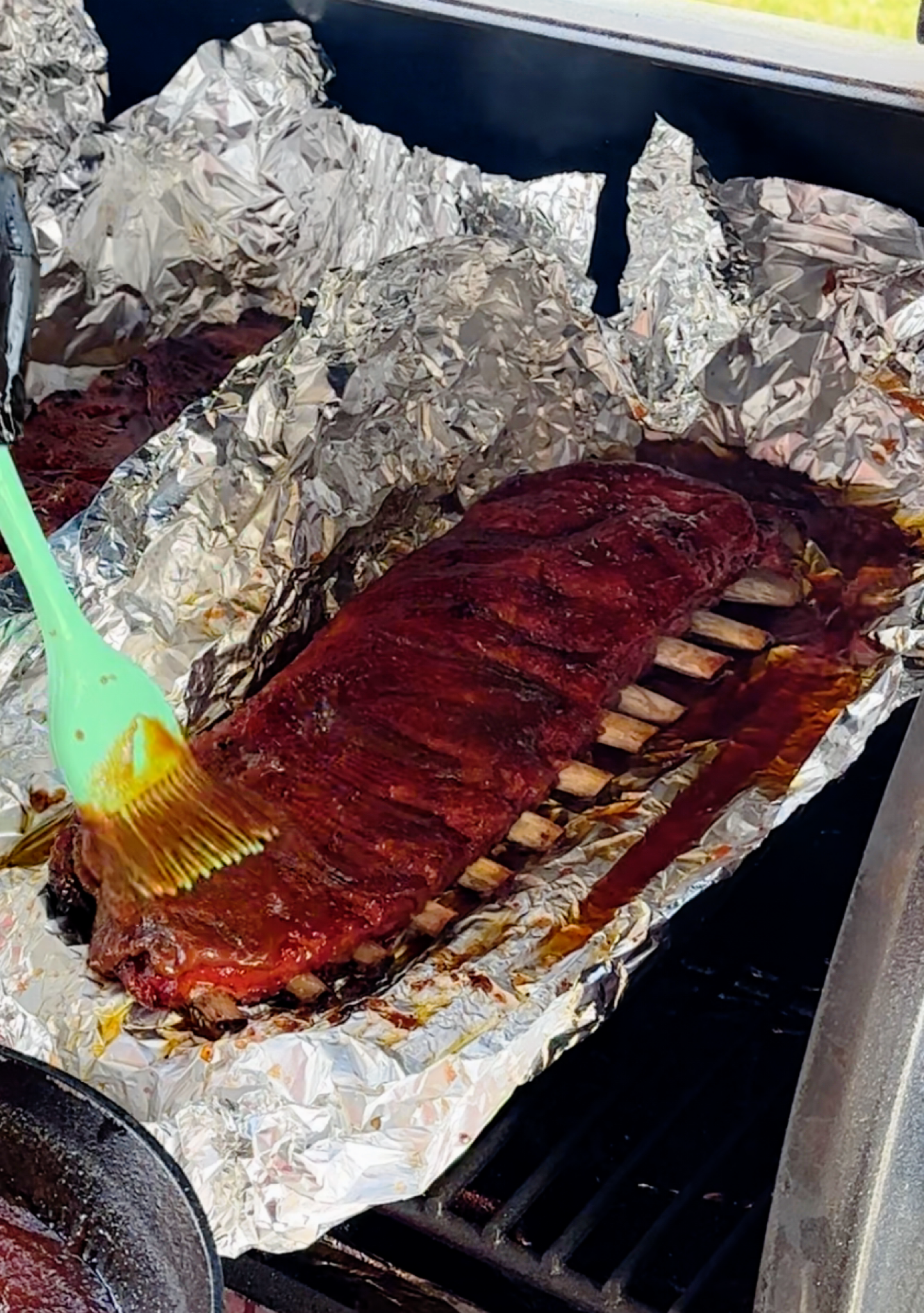 Brushing St. Louis style ribs with BBQ sauce. 