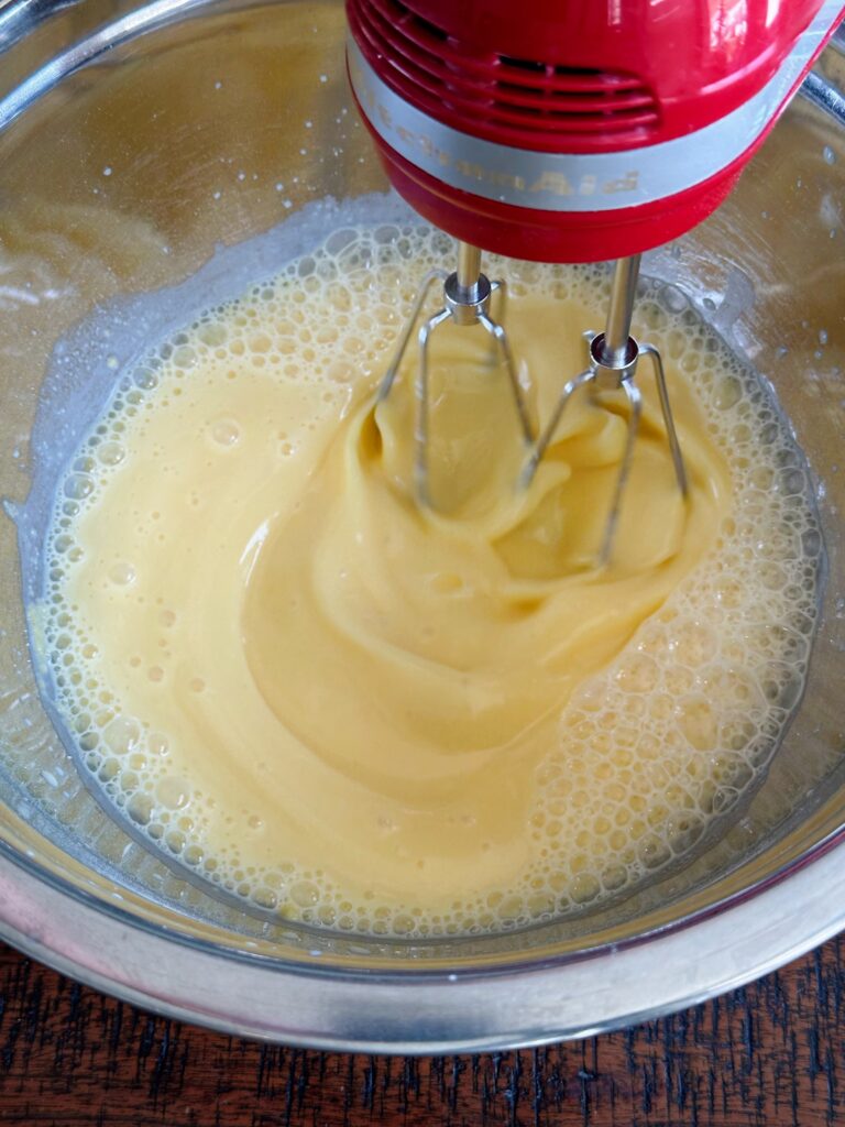 Mixing cold milk and vanilla pudding packet together. 