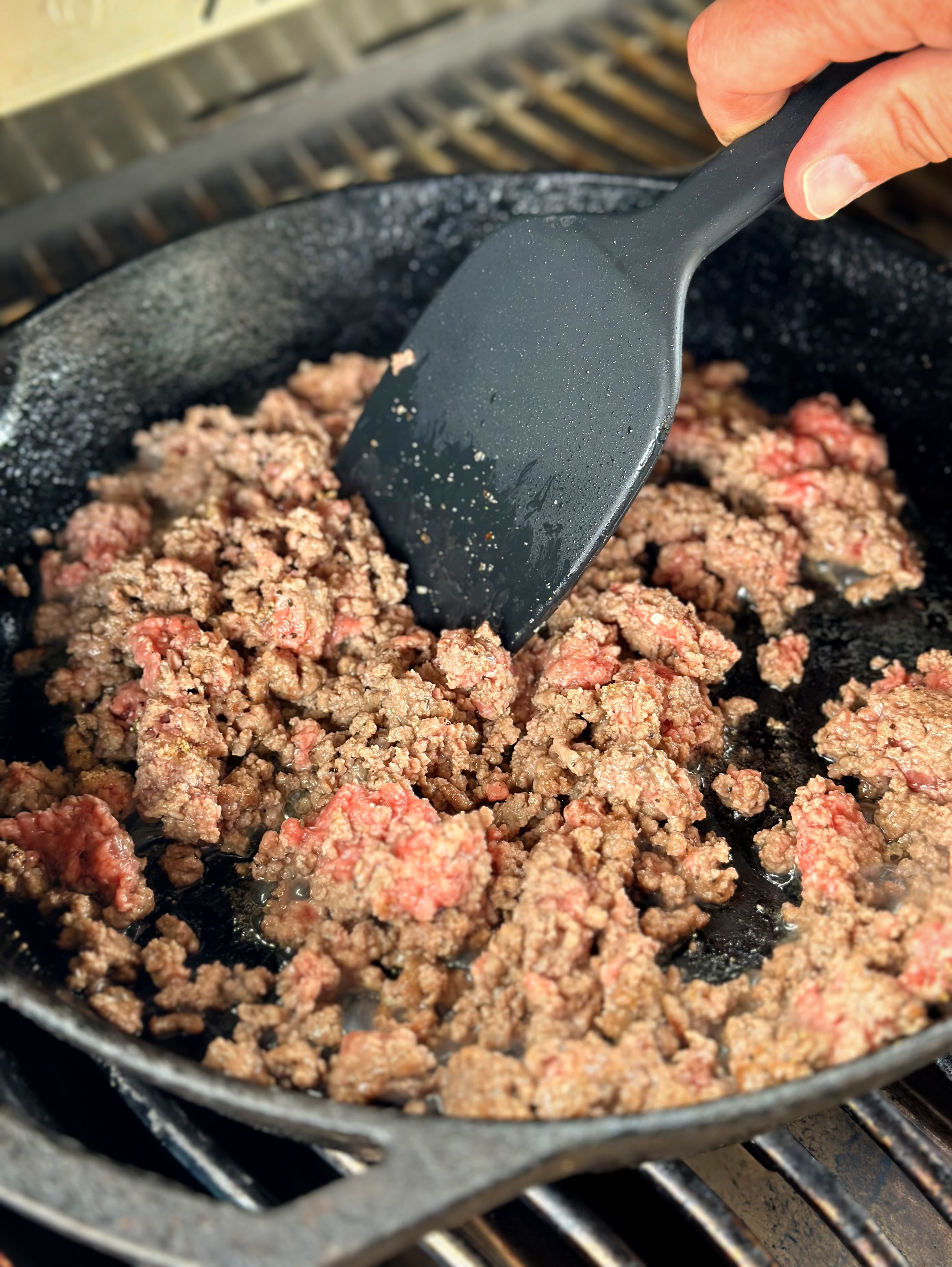 Ground beef in a skillet on the grill. 